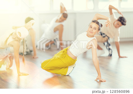 Teen girl with group of teenage friends, learn to dance hip hop Teen girl with group of teenage friends, learn to dance hip hop 128560896