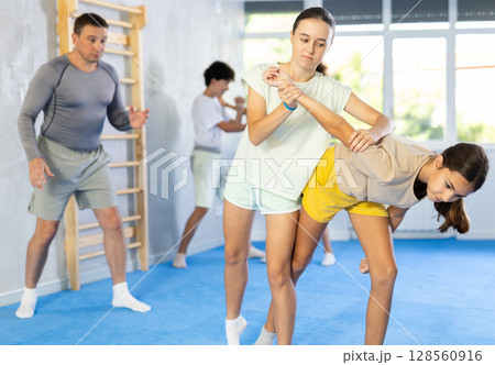 Girls and boys adolescents of performing protection with wring hands during training in self-defense Girls and boys adolescents of performing protection with wring hands during training in self-defense 128560916