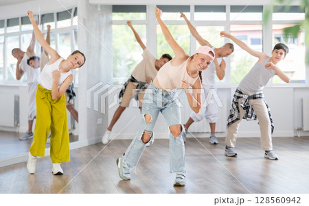 Teenage girl practicing hip hop slide moves in training hall Teenage girl practicing hip hop slide moves in training hall 128560942