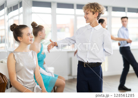 Boys invite girls to dance. Teenagers children in festive clothes dance in pairs in studio 128561285