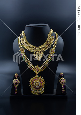 Heavy Traditional Indian Bridal Gold Necklace Set with Earrings on Display Heavy Traditional Indian Bridal Gold Necklace Set with Earrings on Display 128561501