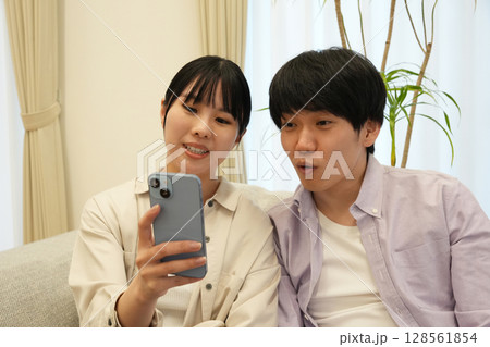 スマホを見るカップル 128561854