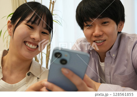 スマホを見るカップル スマホを見るカップル 128561855