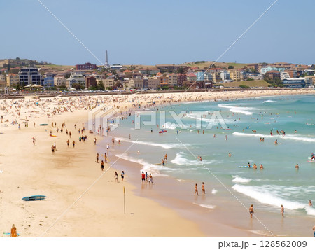 December 16, 2009. Sydney, Australia. Bondi Beach on a sunny day, bustling with sunbathers and swimmers enjoying the iconic sandy shores and clear blue waters. 128562009