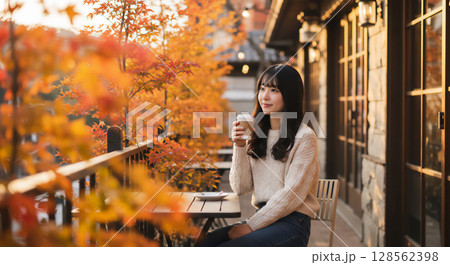 秋のテラスで過ごす女性のリラックスタイム、カフェのひととき 128562398