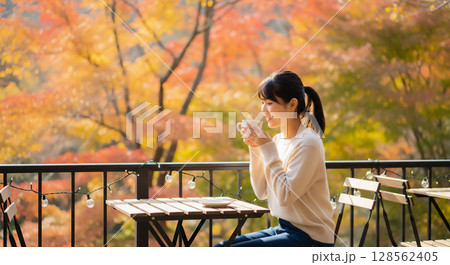 秋のテラスで過ごす女性のリラックスタイム、カフェのひととき 秋のテラスで過ごす女性のリラックスタイム、カフェのひととき 128562405