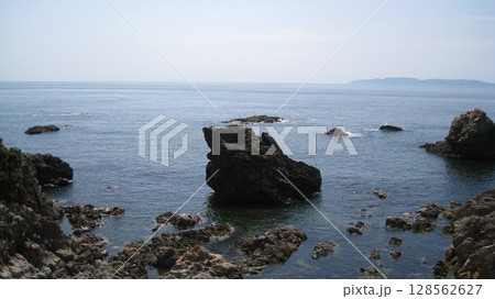 景勝地の笹川流れの日本海と奇岩に咲き誇る岩ユリのオレンジの花 景勝地の笹川流れの日本海と奇岩に咲き誇る岩ユリのオレンジの花 128562627
