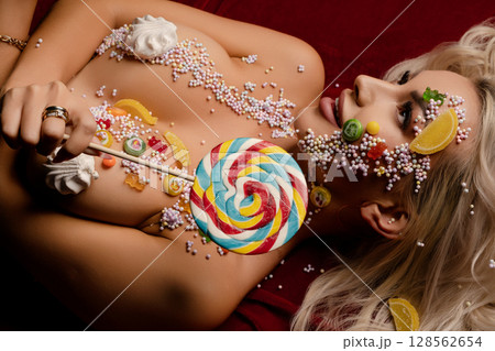 Woman showcases vibrant candy body art in a creative studio setting Woman showcases vibrant candy body art in a creative studio setting 128562654