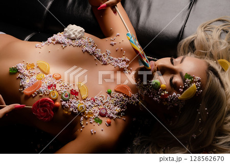 Woman posing with colorful candy bodyart in a beauty studio setting Woman posing with colorful candy bodyart in a beauty studio setting 128562670