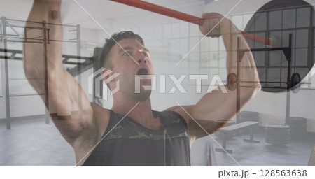 Composite of caucasian man lifting barbell weights, and gym 128563638