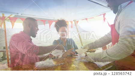 Composite of happy african american couple buying takeaway food, and mountain countryside Composite of happy african american couple buying takeaway food, and mountain countryside 128563742