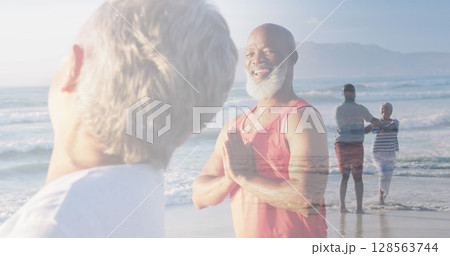 Composite of happy diverse senior couple doing yoga, and dancing on beach Composite of happy diverse senior couple doing yoga, and dancing on beach 128563744