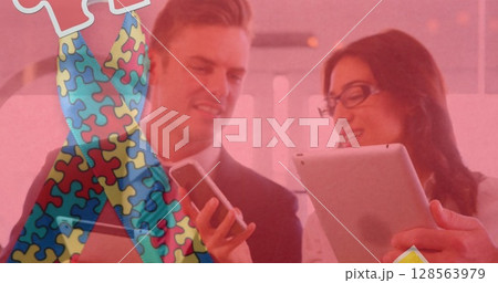 Image of colourful puzzle pieces ribbon over business people using digital devices Image of colourful puzzle pieces ribbon over business people using digital devices 128563979