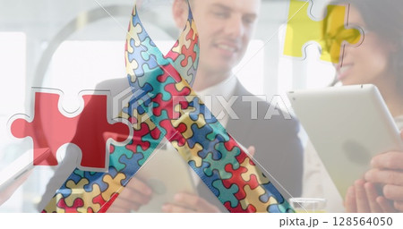 Image of colourful puzzle pieces ribbon over business people using digital devices Image of colourful puzzle pieces ribbon over business people using digital devices 128564050