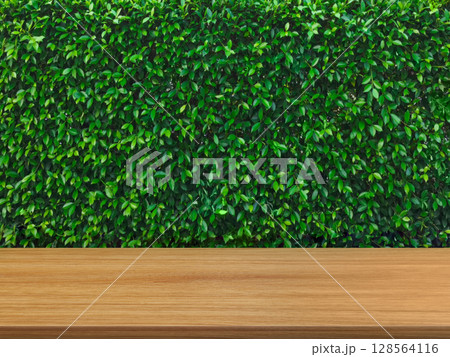 Empty wooden table, green bush background. Empty wooden table, green bush background. 128564116