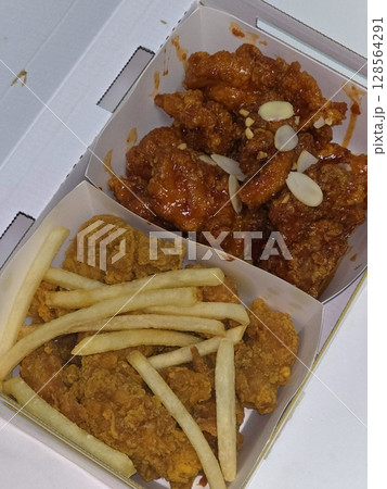 Crispy Korean fried chicken glazed in sweet and spicy sauce, served with golden French fries. A perfect combo of bold flavor and satisfying crunch in every delicious bite. 128564291