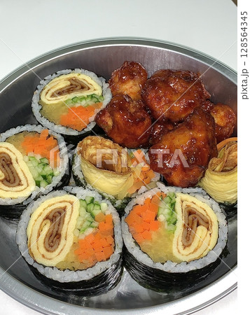 A delicious combination of kimbap and dakgangjeong. The crispy, sweet, and spicy Korean fried chicken pairs perfectly with the savory rice rolls, creating a flavorful and satisfying meal. 128564345