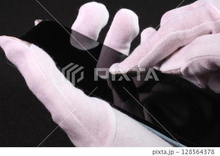 手袋をしてスマホを操作する女性の手 128564378