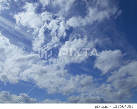 青空を進んで行く白い雲 青空を進んで行く白い雲 128564383