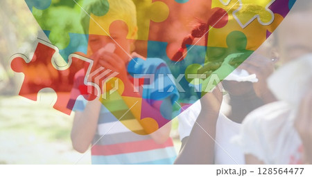 Image of colourful puzzle pieces heart over children blowing their noses 128564477