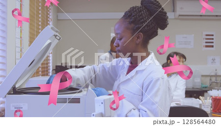 Image of pink breast cancer ribbons falling over group of working doctors 128564480