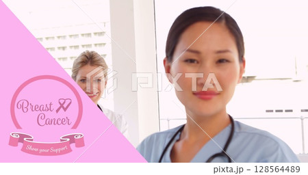 Image of pink breast cancer ribbon over two female smiling doctors 128564489
