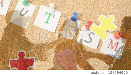 Image of colourful puzzle pieces heart and autism text over happy friends at summer beach party Image of colourful puzzle pieces heart and autism text over happy friends at summer beach party 128564490