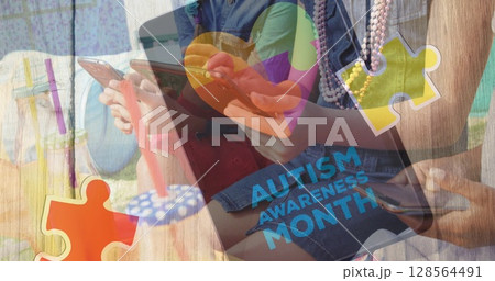 Image of colourful puzzle pieces and autism text over friends using smartphone and tablet 128564491