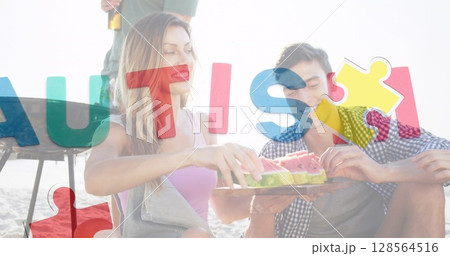 Image of colourful puzzle pieces heart and autism text over happy friends at summer beach party 128564516