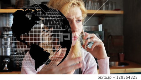 Image of globe spinning over woman using smartphone 128564825