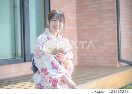 扇子と浴衣と笑顔の女性 128565228