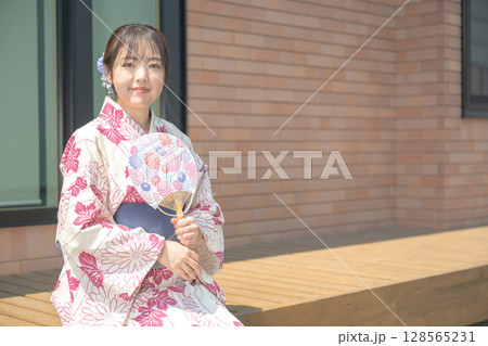 軒先で涼む浴衣の女性 128565231