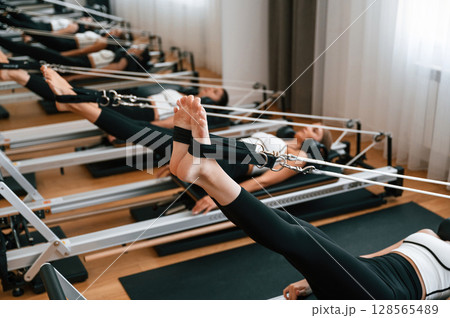 Legs stretching. Women in fitness center are doing exercises 128565489