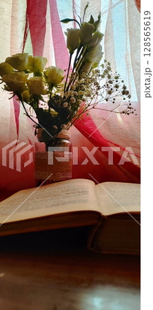 Still life of roses in vintage mason jar. Still life with book, coffee, and flowers. Still life of roses in vintage mason jar. Still life with book, coffee, and flowers. 128565619