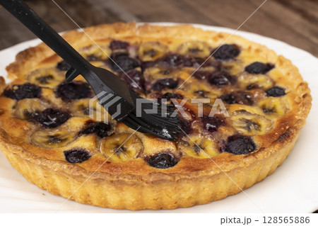 焼きあがったフルーツタルトを切り分ける 128565886