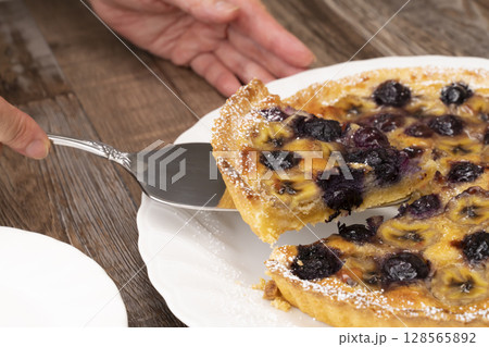 焼きあがったフルーツタルトを切り分ける 128565892