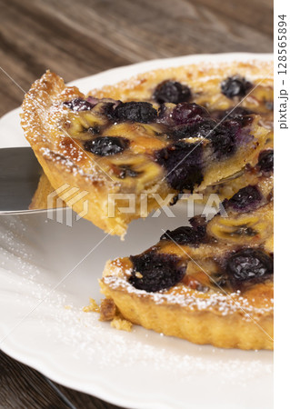 焼きあがったフルーツタルトを切り分ける 128565894