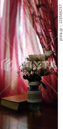 Still life of roses in vintage mason jar. Still life with book, coffee, and flowers. 128566257