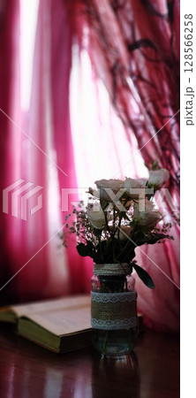 Still life of roses in vintage mason jar. Still life with book, coffee, and flowers. 128566258