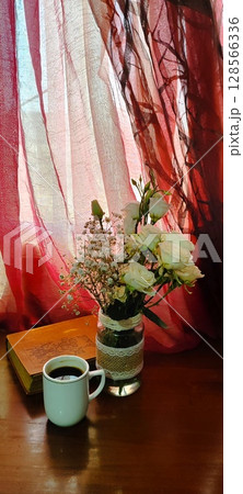 Still life of roses in vintage mason jar. Still life with book, coffee, and flowers. 128566336