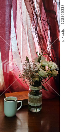 Still life of roses in vintage mason jar. Still life with book, coffee, and flowers. 128566338