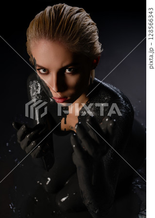 Striking beauty showcases body art with intricate paint and tattoos 128566343