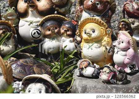 古民家の庭先に並べられた たぬきの置物 128566362