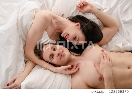 Romantic couple enjoying intimate moments in a cozy bedroom setting 128566370