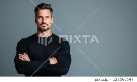 A muscular man stands confidently with crossed arms in a studio setting, showcasing strength and charm in a neutral environment Generative AI A muscular man stands confidently with crossed arms in a studio setting, showcasing strength and charm in a neutral environment Generative AI 128566547