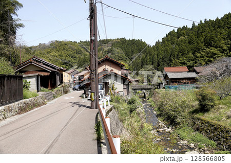 石見銀山 街並み地区の風景 銀山川と石でできたアーチの橋が見える 128566805