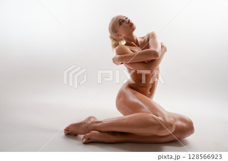 Elegant woman in an athletic pose showcases beauty and strength 128566923
