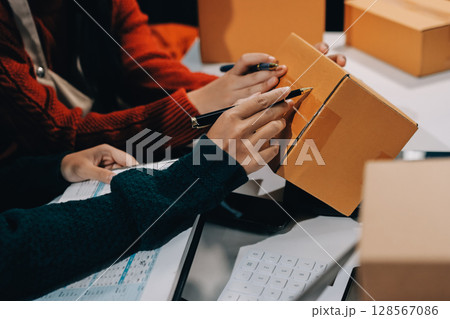 Portrait of Starting small businesses SME owners, two Asian woman check online orders Selling products working with boxs freelance work at home office, sme business online small medium enterprise 128567086