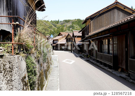 石見銀山 町並み地区の素朴な古民家と山並み 石見銀山 町並み地区の素朴な古民家と山並み 128567218