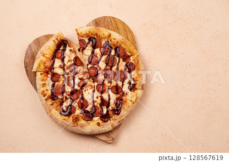 Delicious sausage pizza with a generous layer of cheese and juicy barbecue sauce, perfect for any celebration Delicious sausage pizza with a generous layer of cheese and juicy barbecue sauce, perfect for any celebration 128567619